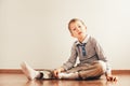 Child sitting on the floor putting on his socks with an expression of effort, concept of autonomy Royalty Free Stock Photo