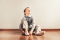 Child sitting on the floor putting on his socks with an expression of effort, concept of autonomy