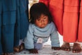 Child sitting on floor of Uros Island, Peru. Uru or Uros - indigenous people of Peru and Bolivia