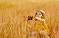 A child is sitting in the grass of a summer meadow with a pinwheel