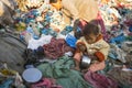 Child is sitting while her parents are working on dump. In Nepal annually die 50,000 children, in 60% of cases - malnutrition.