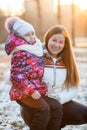 Child sitting with mother on a walk in park, the sun's rays of sunset Royalty Free Stock Photo