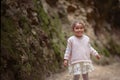 The child is sitting on a mountain of sand. Blue sky. A little g Royalty Free Stock Photo