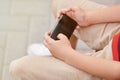 Child sitting outside school and playing games on his cell phone Royalty Free Stock Photo