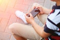 Child sitting outside school and playing games on his cell phone Royalty Free Stock Photo