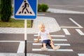 A child is sitting on the road at a pedestrian crossing and holding his leg, traffic rules for children Royalty Free Stock Photo