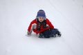 Child is sitting on the snow