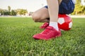 A child is sitting on a soccer ball on the grass of stadium`s field. Training and sports for children concept Royalty Free Stock Photo