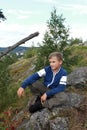 Child sitting on stone of Mount Paaso in Karelia Royalty Free Stock Photo