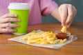 Child sitting at the table eating French fries with ketchup and drink, close-up Royalty Free Stock Photo