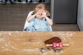 Child Sitting at Table Preparing Gingerbread Dough with Baking Tools Royalty Free Stock Photo
