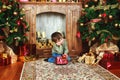 Child sitting under the Christmas tree with gifts Royalty Free Stock Photo