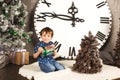 Child sitting under the Christmas tree with gifts Royalty Free Stock Photo