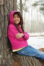 Child sitting under tree in winter Royalty Free Stock Photo