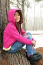 Child sitting under tree in winter Royalty Free Stock Photo