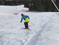 Child skier performs a high jump with the ski in Chopok, Slovakia. Winter season, colorful jacket. Small boy jumping on downhill Royalty Free Stock Photo