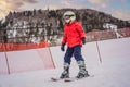 Child skiing in mountains. Active toddler kid with safety helmet, goggles and poles. Ski race for young children. Winter Royalty Free Stock Photo