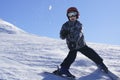 Child skiing and throwing snowball
