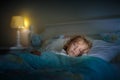 Child sleeping in dark bedroom. Little boy napping
