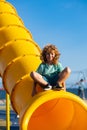 Child on slide playground area. Cute boy in the kids park having fun.