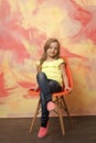 Child or small happy girl sitting on orange chair Royalty Free Stock Photo