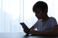 Child with smartphone at table. Danger of internet Royalty Free Stock Photo
