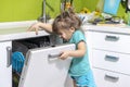 A child smells a dishwasher