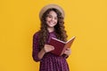 child smile with frizz hair read book on yellow background