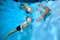 A child, a smiling little boy, swims towards his father& x27;s arms underwater in the children& x27;s pool. Healthy lifestyle Royalty Free Stock Photo