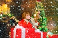 Child in snow. Cheerful cute child opening a Christmas present. Happy child with Christmas gift box. Winter kid. Funny Royalty Free Stock Photo