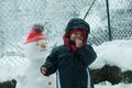 Child in the snow with snowman Royalty Free Stock Photo