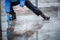 A child in snowboots boots is standing in a puddle of melted snow. Ice on the roads in the city. Not cleaned from snow and ice Royalty Free Stock Photo