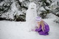 Child, snowman and winter forest