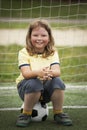 Child soccer football player. Boy with ball on green grass.