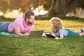 Child son with father learning outdoor by studying online and working on laptop.