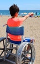 Child on the wheelchair on the beach in summer