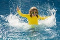 Child splashing in summer water pool. Kid splash in pool. Excited happy kid boy jumping in pool, water fun. Kid jumping Royalty Free Stock Photo