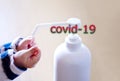 A child sprays her hands with antiseptic from a plastic spray bottle. Hands with a bottle close-up on a blue background and covid-