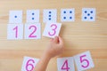 The child spreads cards with numbers to cards with dots. The study of numbers and mathematics