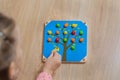 The child spreads the color of the wooden balls. Game for children