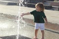 Little cute male baby standing near fountain. Concept of walking in city with children Royalty Free Stock Photo