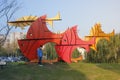 Child standing before the city sculpture which being colorful swimming fish