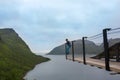 Child, standing on the edge of a 44 meter long viewing platform, overlooking the water of Bergsfjord, enjoying the view on Senja