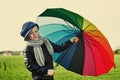 The child, standing under a colored umbrella on the green meadow Royalty Free Stock Photo