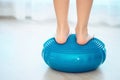 The child stands on a special inflatable pillow for the prevention and treatment of hallux valgus at home. Foot muscle training