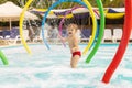 A child stands under fountain having fun with water splashing in the pool Royalty Free Stock Photo