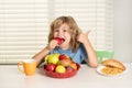 Child with strawberry, summer fruits. Kid preteen boy in the kitchen at the table eating vegetable and fruits during the Royalty Free Stock Photo