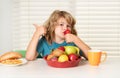 Child with strawberry, summer fruits. Portrait of child eat fresh healthy food in kitchen at home. Kid boy eating Royalty Free Stock Photo