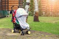 Child in stroller covered with protective net during walk. Baby carriage with anti-mosquito white cover. Midge