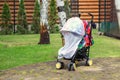 Child in stroller covered with protective net during walk. Baby carriage with anti-mosquito white cover. Midge